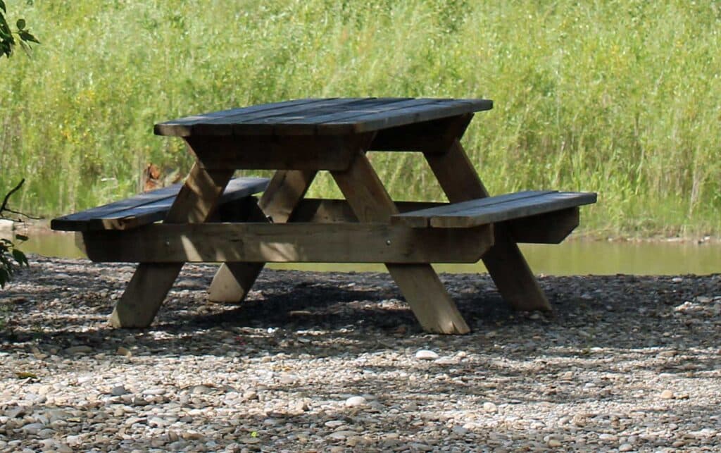 A sturdy wooden picnic table is placed on each short-term campsite